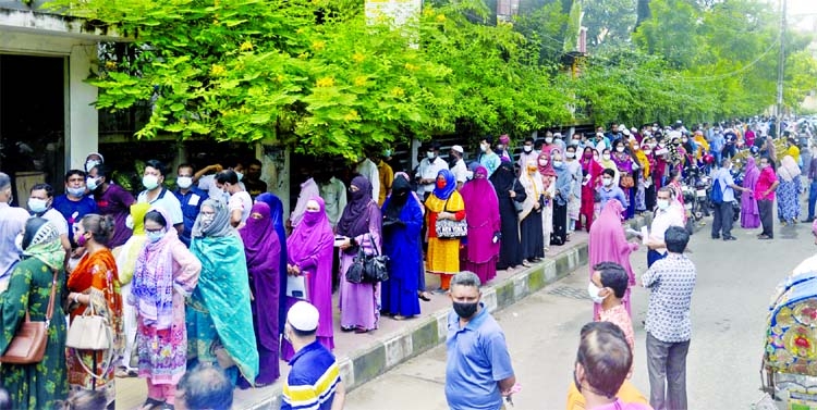 A huge number of people including women rush to different city hospitals everyday to get vaccinated. This photo taken from in front of Government Employees Hospital at Phulbaria shows that they were in long queue without maintaining health rules.