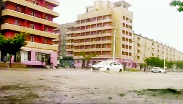 Vehicles pass through flooded streets after heavy rains across South Hamgyong Province, North Korea.