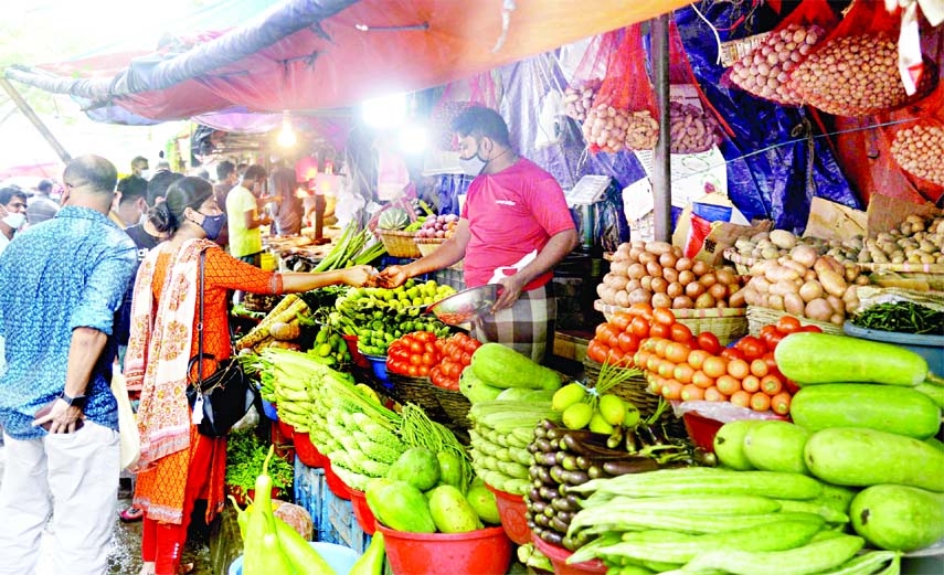 Customers swarm at a kitchen market to buy vegetables in the Hatirpool area of the capital on Friday.
