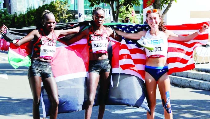 Gold medallist Peres Jepchirchir (center) of Kenya, silver medallist Brigid Kosgei (left) of Kenya and bronze medallist Molly Seidel of the United States posing holding their flags at Sapporo Odori Park, Sapporo, Japan on Saturday.