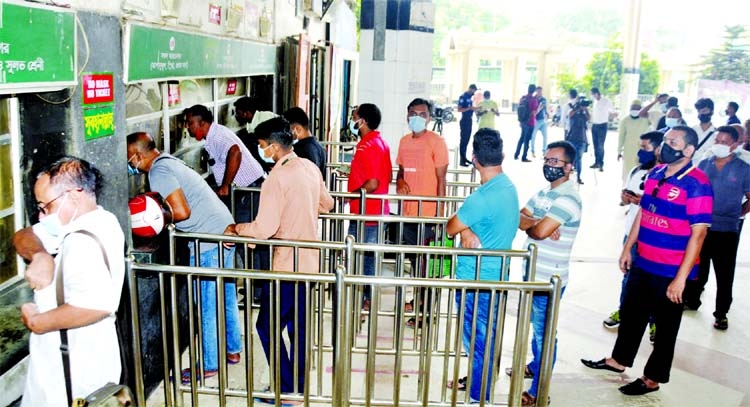 Passengers are seen standing in queues to collect advance tickets at the Kamalapur Railway Station in the capital on Monday as the lockdown will end on Wednesday.