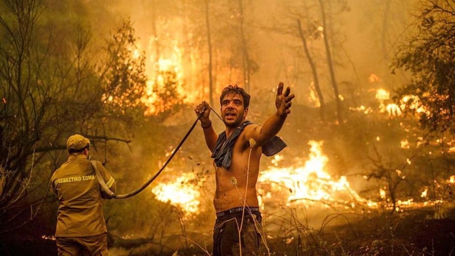 A local resident gestures as he holds n empty water hose during an attempt to extinguish forest fires approaching the village of Pefki on Evia (Euboea) island, Greece's second largest island. Agency photo