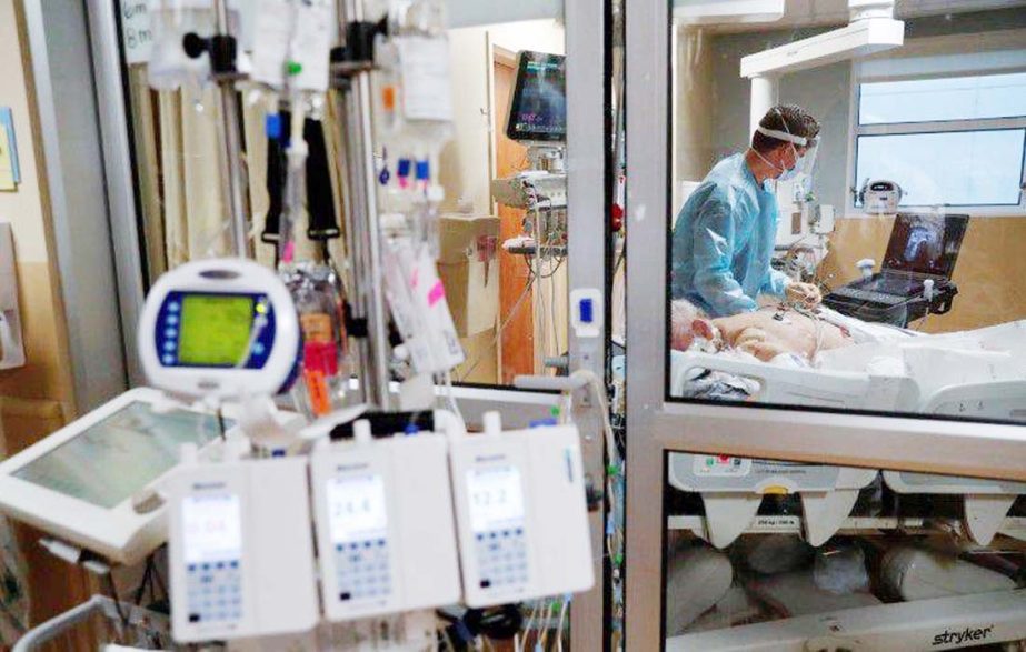 A critical care respiratory therapist works with a coronavirus positive patient in the intensive care unit (ICU) at Sarasota Memorial Hospital in Sarasota, Florida. Agency photo