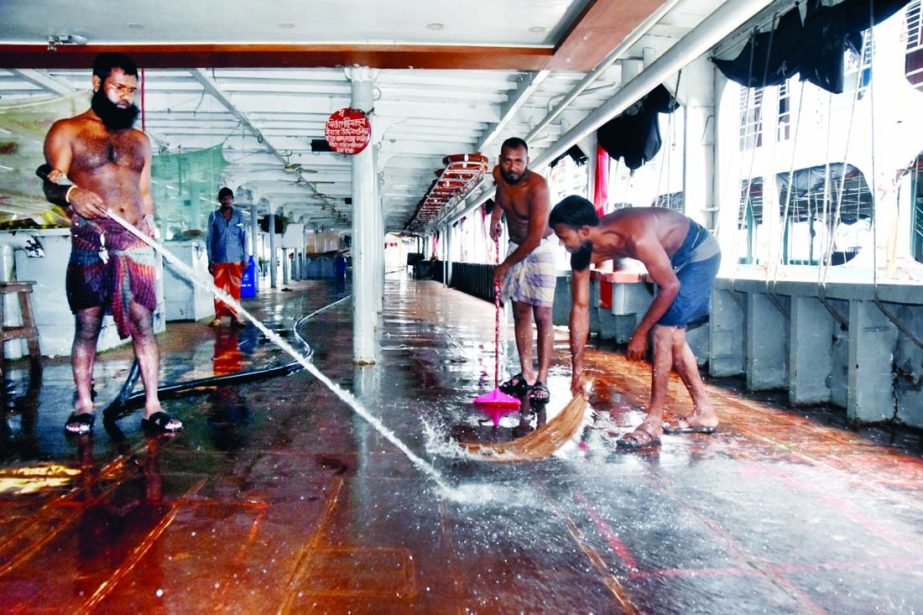 Cleaners wash a launch on Tuesday at Sadarghat Terminal ahead of resumption of water transports today after 18-day strict lockdown.
