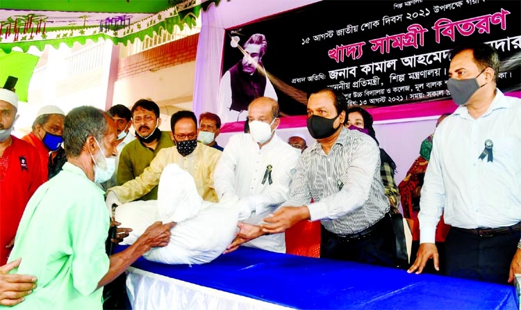 State Minister for Industries Kamal Ahmed Majumder distributes foodstuff among the distressed in the city's Monipur High School and College ground on Friday marking National Mourning Day.