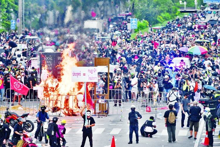 Anti-government demonstrators burn mock body bags, representing casualties of the coronavirus outbreak, and a puppet depicting Thai Prime Minister Prayuth Chan-ocha in Bangkok.