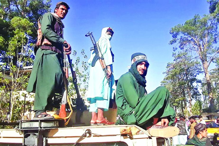 Taliban fighters stand on a vehicle along the roadside in Herat on last Friday.