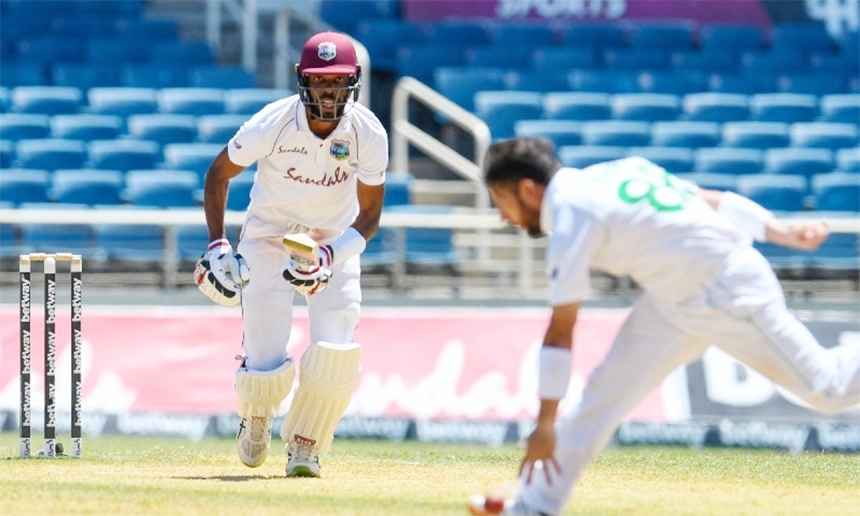 Roston Chase (left) of West Indies hits past Yasir Shah (right) of Pakistan during day 4 of the 1st Test between West Indies and Pakistan at Sabina Park on Sunday.