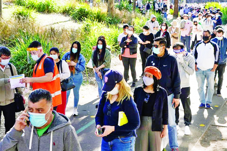 People wait in line outside a coronavirus vaccination centre at Sydney Olympic Park during a lockdown to curb the spread of an outbreak in Sydney, Australia on Monday.