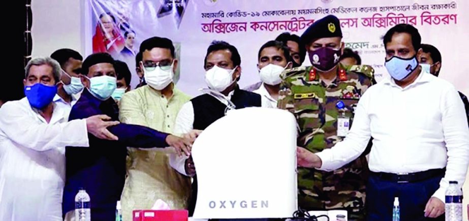 State Minister for Housing and Public Works Sharif Ahamed at a function hands over 50 oxygen concentrators and 500 pulse oximeters to Brigadier General Fazlul Karim, Director, Mymensingh Medical College Hospital for the treatment of corona patients held a