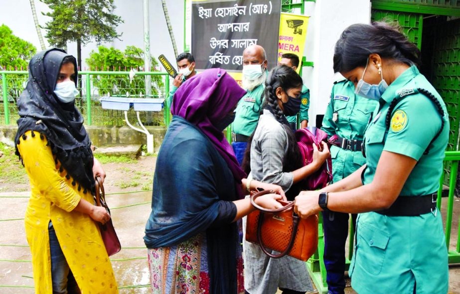 A female police checking a woman’s bag at the entrance of Hussaini Dalan in the capital on Wednesday.