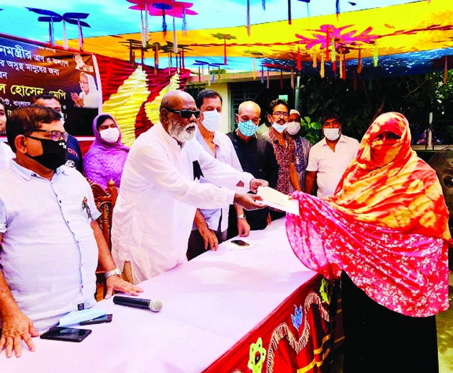 Md. Mokbul Hossain, MP from Pabna-3 and Chairman of the Standing Committee on Land Ministry hands over donation cheques from the PM's Relief Fund among the sick people of Bhangura on Wednesday. NN photo