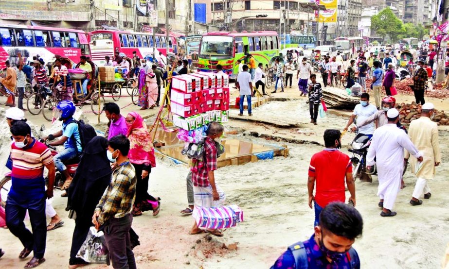 People walk on a dilapidated road at Gulistan area in the capital on Thursday. NN photo