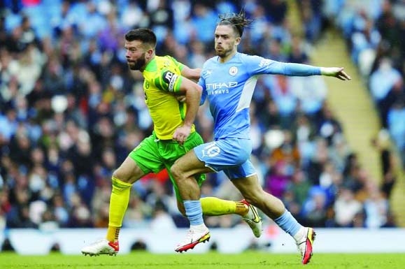 Norwich City's defender Grant Hanley (left) vies with Manchester City's midfielder Jack Grealish (right) in their English Premier League football match at the Etihad Stadium in Manchester, north west England on Saturday.