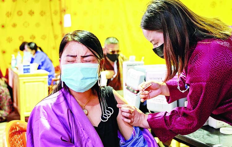 A health worker inoculates woman with the jab of coronavirus vaccine at a temporary vaccination centre in Thimpu.