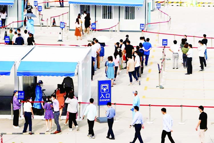 Staff members of Shanghai Pudong International Airport line up at a nucleic acid testing site to test for Covid-19 in Shanghai, China.