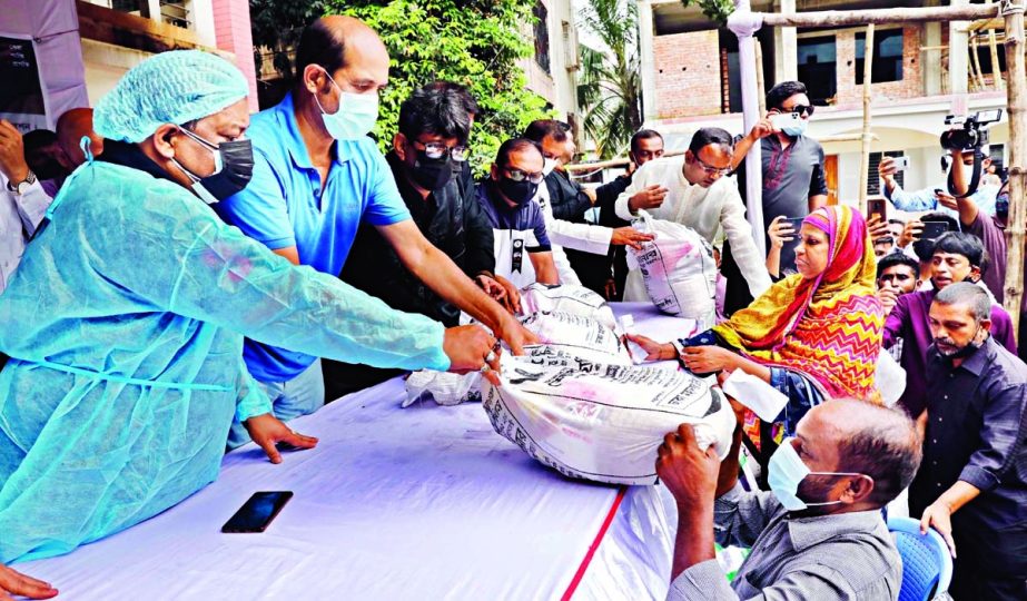 DNCC Mayor Atiqul Islam distributes foodstuff among the destitute at Uttar Kafrul High School ground in the city on Monday.