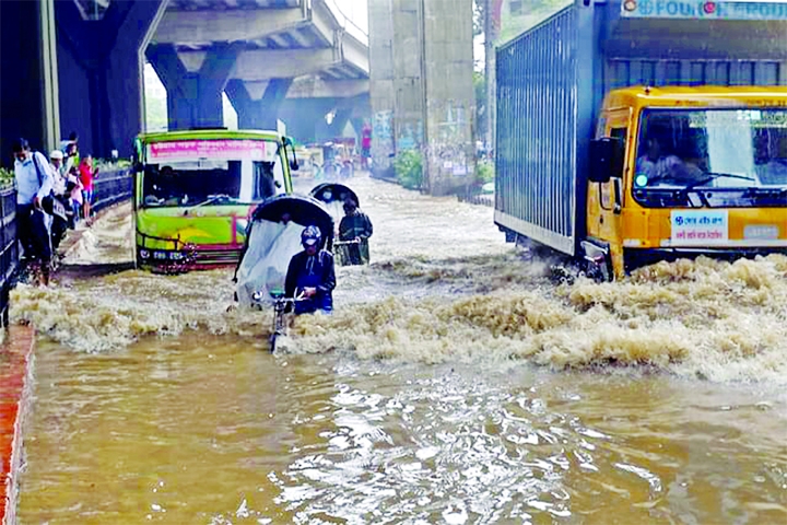 Vehicles ply on a waterlogged road in the No 2 Agrabad Gate area of the Port City of Chattogram on Wednesday after heavy rains.