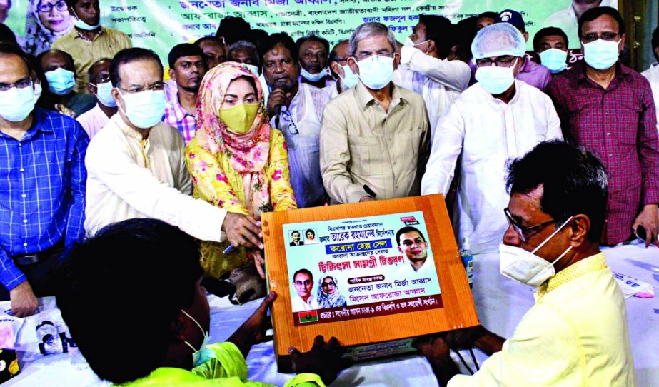 BNP Secretary General Mirza Fakhrul Islam Alamgir hands over health protective equipment among the commoners after inaugurating corona help cell at Friends Convention Center in the city's Goran on Thursday. NN photo