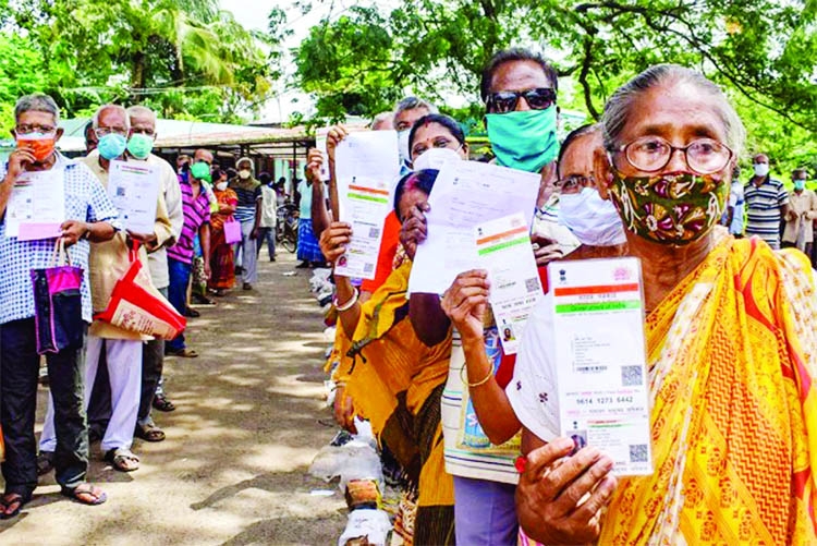 Beneficiaries show their Aadhar card and ragistration form wait in a long queue to receive a dose of COVID-19 vaccine at a vaccination centre in Nadia, India.