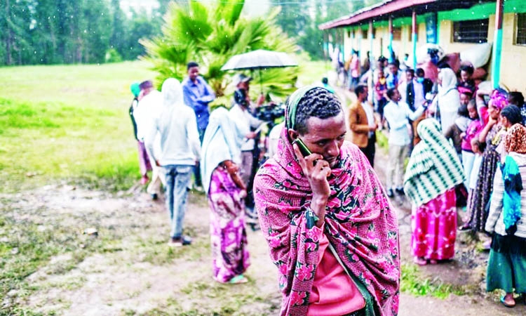 An internally displaced man from Amhara Region talks on the phone at the Addis Fana School where he is temporary sheltered, in the city of Dessie, Ethiopia.