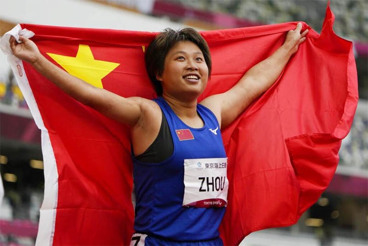 Zhou Xia of China poses their national flag after winning the women's 100m T35 at the Tokyo 2020 Paralympics Games in Tokyo on Friday.