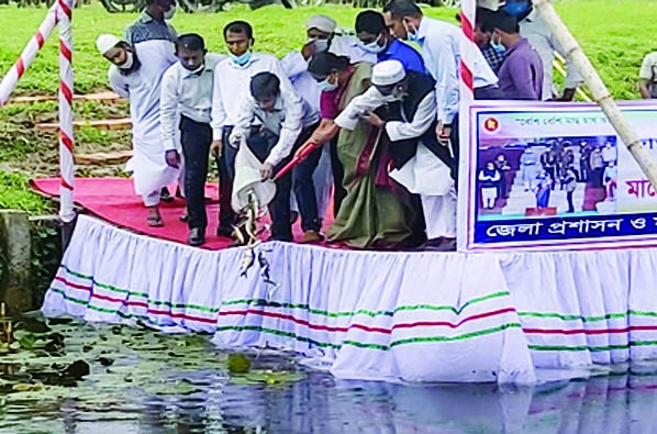 Shahida Sultana, Deputy Commissioner, Gopalganj and Biswajit Bairagi, District Fisheries Officer along with other high officials of the district releases fish fries into the helipad pond of Gopalganj on the occasion of National Fisheries Week-2021 on Satu