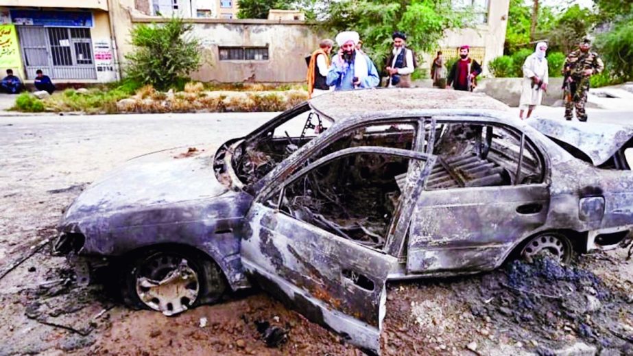 Taliban fighters investigate a damaged car after multiple rockets were fired in Kabul on Monday. Agency photo