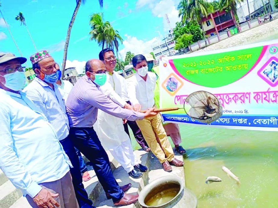 Md. Suridh Salehin, Upazila Nirbahi Officer, Betagi, Barguna, releasing fish fries at a pond in front of the upazila parishad yesterday. NN photo