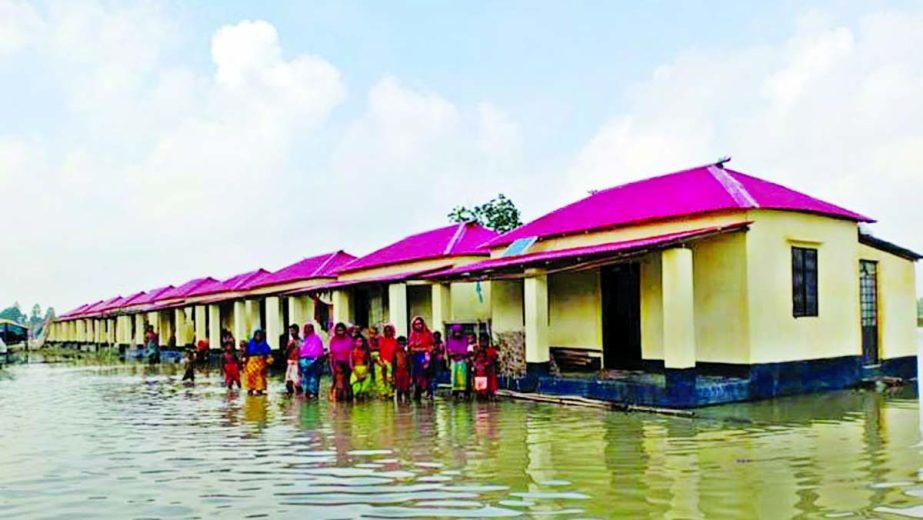 Homeless families now living in the houses donated by Prime Minister recently in Jamalpur have been marooned by flood water. This photo was taken on Tuesday. NN photo
