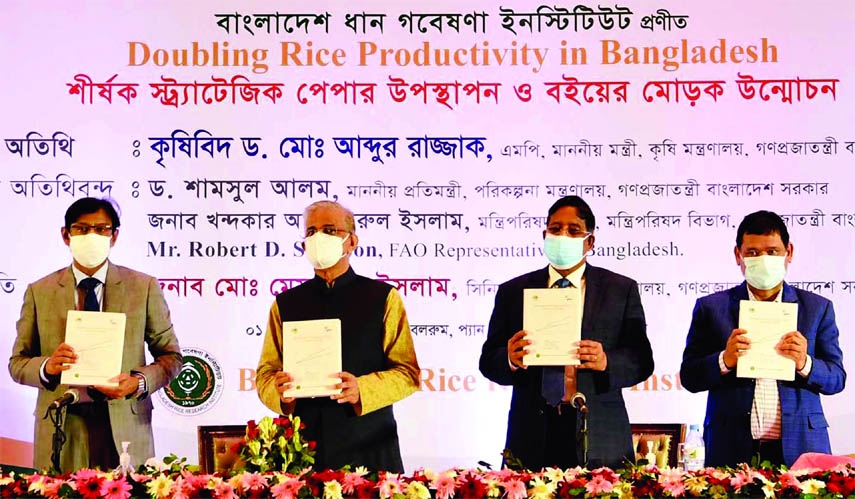 Agriculture Minister Dr. Abdur Razzaque, among others, holds the copies of a book titled 'Doubling of Rice Production in Bangladesh' at Hotel Sonargaon in the city on Wednseday.