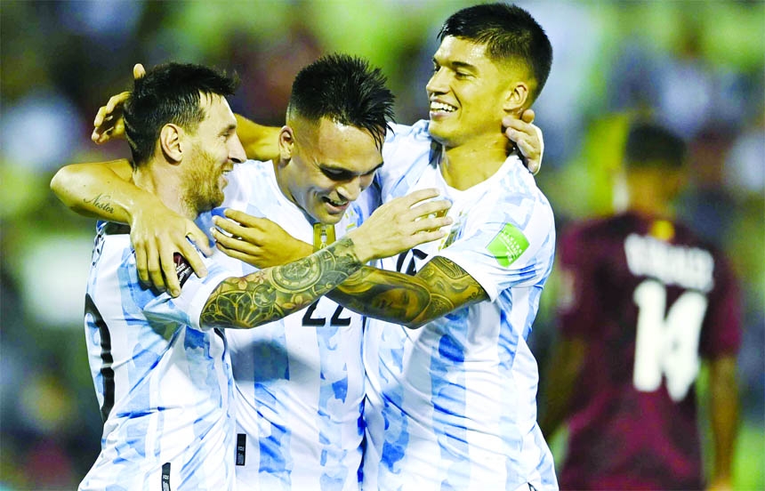 Argentina's Joaquin Correa (right) celebrates scoring his side's second goal against Venezuela with teammates Lautaro Martinez (center) and Argentina's Lionel Messi during a qualifying soccer match for the FIFA World Cup Qatar 2022 in Caracas, Venezuel