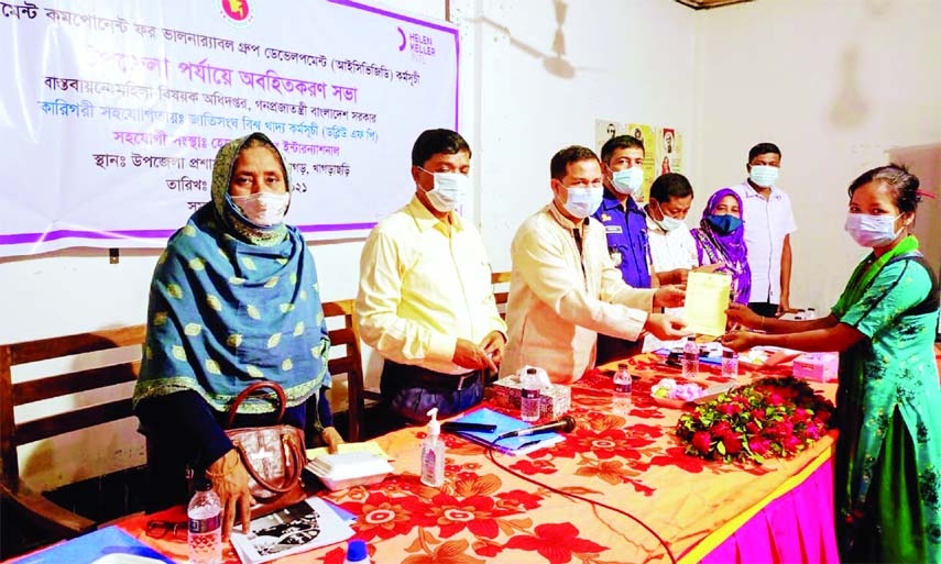 Ramgarh upazila chairman Bishwa Pradeep Kumar Karbari distributes VGD cards to theneedy families under ICVGD project on Thursday.