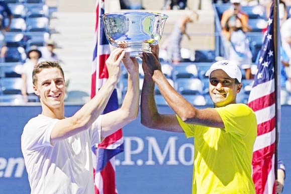 Joe Salisbury of Great Britain (left) and teammate Rajeev Ram of the United States, hold their men's doubles trophy after defeating Bruno Soares of Brazil and Jamie Murray of Great Britain at the US Open tennis championships 2021 in New York on