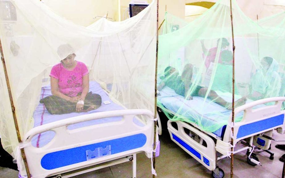 Dengue-infected patients sit under the mosquito nets after being hospitalised at Tej Bahadur Sapru Hospital in Prayagraj, in the northern state of Uttar Pradesh, India on Monday. Agency photo