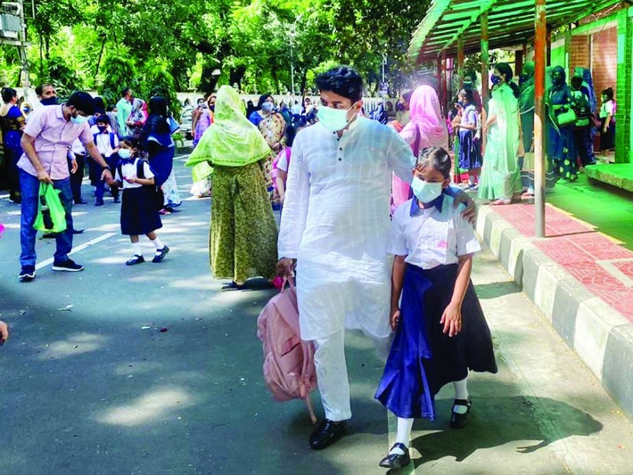 Guardians return homes with students from Udayan Uchcha Madhyamik Bidyalaya at the end of class on Monday following health norms. NN photo