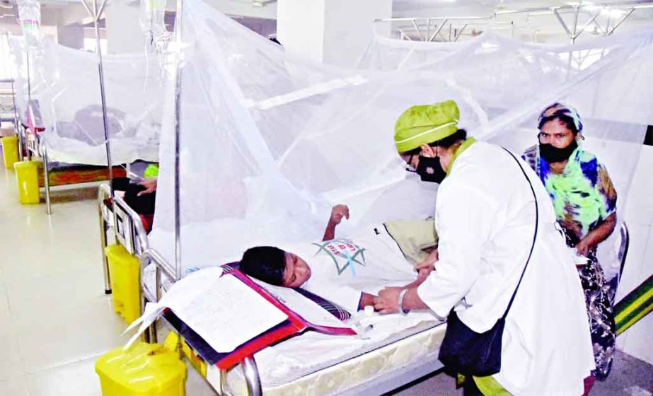 A nurse cares for a boy infected with dengue at the Sir Salimullah Medical College and Hospital in the capital on Monday. NN photo