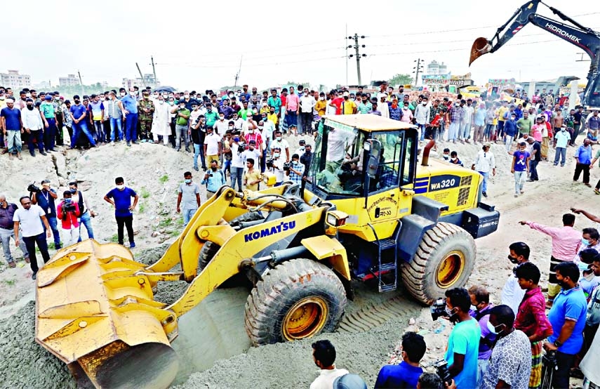 Dhaka North City Corporation conducts an eviction drive with a bulldozer at Gabtoli in the capital on Monday.
