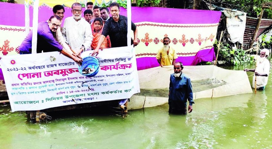 Sirajul Islam Khan, Chairman of Adamdight Upazila Parishad in Bogura, releases fish fries in a water body on Tuesday. NN photo