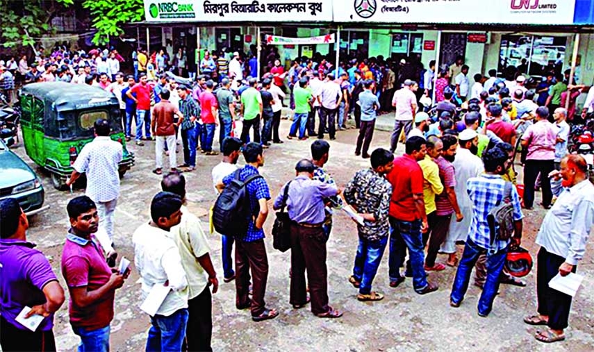People form a long queue on the premises of BRTA Mirpur office in Dhaka to deposit registration and fitness fees on cars and other motor vehicles. This photo was taken yesterday. NN photo