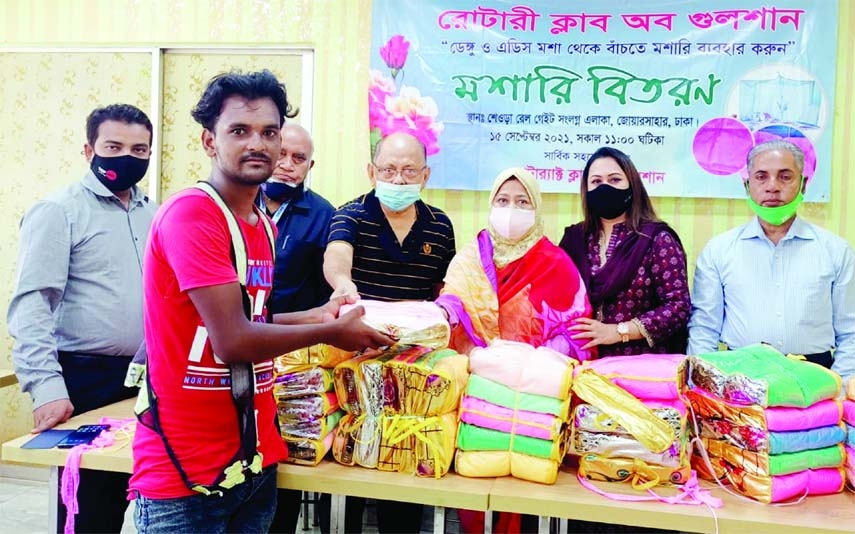 President Rotary Club Gulshan Rotarian Nadira Mahmud distributes mosquito curtains among destitute people at Baridhara adjacent to Shaora Railgate (Kukumbari) area in the capital on Wednesday.