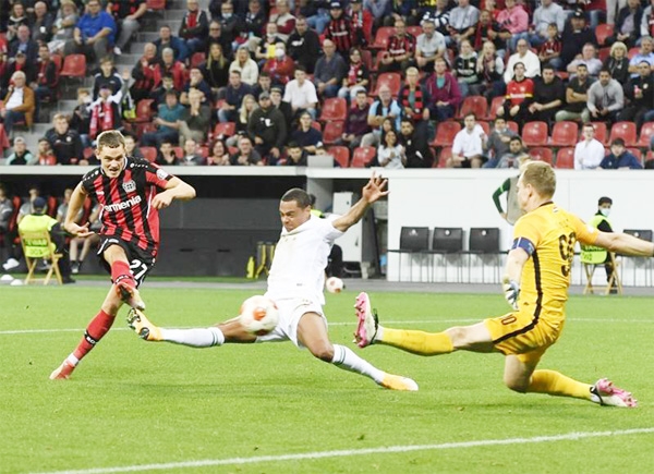 Leverkusen's German forward Florian Wirtz (left) scores the 2-1 goal past Ferencvaros' Hungarian goalkeeper Denes Disbusz during the UEFA Europa League Group G football match between Bayer 04 Leverkusen and Ferencvaros in Leverkusen, western Germany on