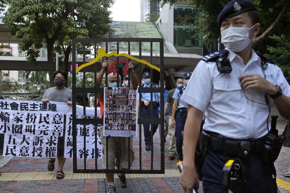 A police officer guard at a street during a protest against an election committee that will vote for the city's leader in Hong Kong Sunday, Sept. 19, 2021. Hong Kong's polls for an election committee that will vote for the city's leader kicked off Sund