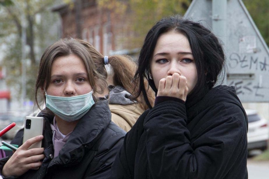 Students stand near the Perm State University in Perm, about 1,100 kilometers (700 miles) east of Moscow, Russia, Monday, Sept. 20, 2021. A gunman opened fire in a university in the Russian city of Perm on Monday morning, leaving at least eight people dea