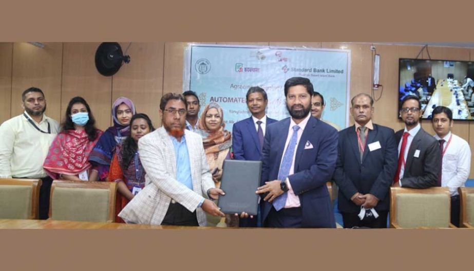 Md Forkan Hossain, General Manager of Bangladesh Bank (BB) and Khondoker Rashed Maqsood, Managing Director and CEO of Standard Bank Limited, exchanging document after signing an agreement to deposit treasury invoices on behalf of Bangladesh Government thr