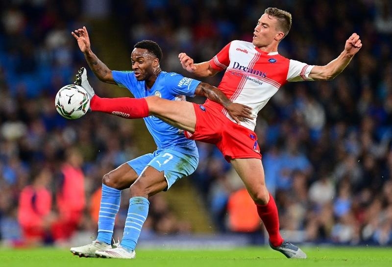 Manchester City's midfielder Raheem Sterling (left) vies with Wycombe Wanderers' midfielder David Wheeler during the English League Cup 3rd round football match at the Etihad stadium in Manchester, northwest England on Tuesday. Agency photo
