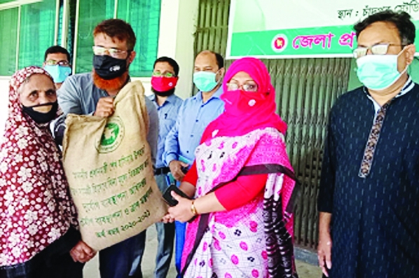 Chandpur Deputy Commissioner Anjana Khan Majlish hands over PM's gift packs to 260 poor and destitute families on Wednesday at Chandpur Stadium. Press Club President Iqbal Hossain is seen in the picture.
