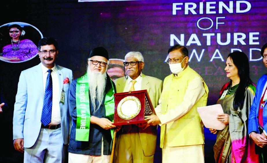 Information and Broadcasting Minister Dr Hasan Mahmud hands over 'Friends of Earth' and 'Miss Earth' environment-friendly citations among the recipients at Hotel Radisson in the city on Friday. NN photo