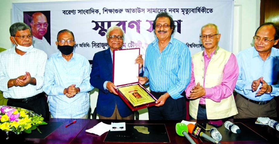 Dhaka University Emeritus Professor Serajul Islam Choudhury hands over a crest to photojournalist ABM Rafiqul Islam for his extraordinary contribution to Independence and Liberation War at a remembrance meeting organised by Ataus Samad Smriti Parishad hel