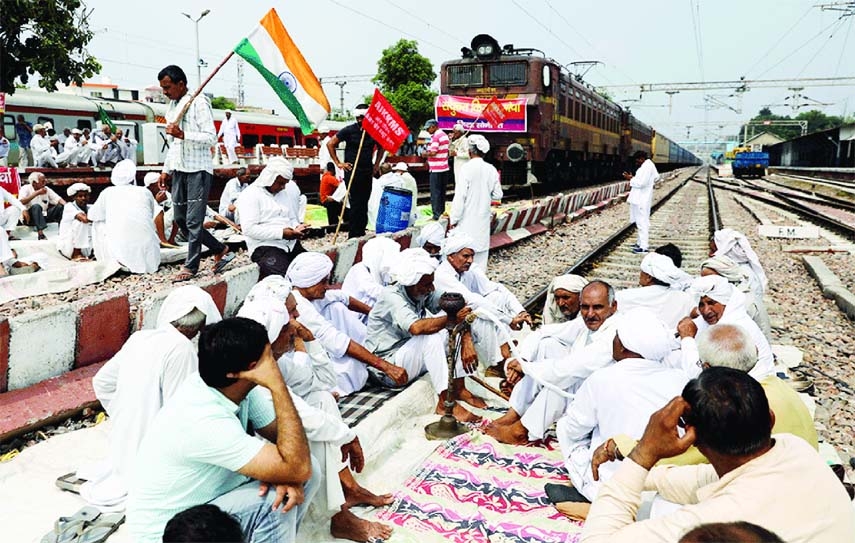 Indian farmers block railway tracks as part of protests against farm laws during protests, in Haryana on Monday.